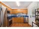 Well-lit kitchen featuring stainless steel appliances, wood cabinets, and a striking blue countertop at 6195 Queensdale Dr, Douglasville, GA 30135