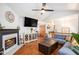 Warm living room featuring a fireplace, TV, hardwood floors, and an open view of the staircase at 6195 Queensdale Dr, Douglasville, GA 30135