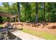 Expansive backyard with mature trees, large rocks, and a cozy patio seating area at 2470 Anderson Estates Ct, Marietta, GA 30064