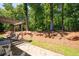 Backyard with a stone wall, mature trees, and lush greenery at 2470 Anderson Estates Ct, Marietta, GA 30064