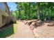 Natural backyard with landscaped retaining wall, mature trees, and a glimpse of a hammock for relaxation at 2470 Anderson Estates Ct, Marietta, GA 30064