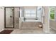 Bright bathroom features a soaking tub, a large walk-in shower, and neutral stone-look tile at 2470 Anderson Estates Ct, Marietta, GA 30064