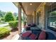 Relaxing front porch with stone columns, wicker furniture, plush cushions, and verdant landscaping at 2470 Anderson Estates Ct, Marietta, GA 30064