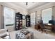 Cozy home office with custom bookshelves, a large work desk, and tufted ottoman at 2470 Anderson Estates Ct, Marietta, GA 30064