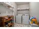 Functional laundry room with washer, dryer, storage shelves, and black and white flooring at 4378 Chestnut Oaks Trce, Lithonia, GA 30038