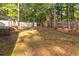 Spacious backyard featuring a mix of grass and dirt with wooded perimeter and privacy fence at 2100 Scarbrough Rd, Stone Mountain, GA 30088