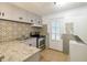 Galley kitchen featuring stainless steel appliances and patterned tile backsplash at 2100 Scarbrough Rd, Stone Mountain, GA 30088