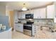 Bright kitchen with stainless steel appliances, granite countertops, and white cabinets at 2100 Scarbrough Rd, Stone Mountain, GA 30088