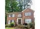 Charming two-story red brick home with landscaped front yard and decorative shutters at 3120 Saint Andrews Cir, Duluth, GA 30096