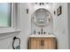 Powder room featuring a modern vanity, round mirror, decorative lighting, and neutral decor at 3250 Cobbs Farm Nw Trl, Marietta, GA 30064