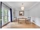Bright dining room with hardwood floors, gray walls, wainscotting, and window with blue curtains at 3250 Cobbs Farm Nw Trl, Marietta, GA 30064