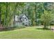 Two-story home surrounded by lush trees and landscaped lawn at 3250 Cobbs Farm Nw Trl, Marietta, GA 30064