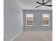 This bedroom features neutral walls, carpet, a ceiling fan, and two windows with blinds at 328 Oaktown Ct, Lawrenceville, GA 30044