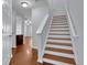 Staircase featuring hardwood floors and white trim creates an inviting transition between levels at 328 Oaktown Ct, Lawrenceville, GA 30044
