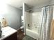 A well-lit bathroom boasts white wall paint, a shower-tub with a shower curtain, and a light-colored countertop at 532 Oakside Pl, Acworth, GA 30102