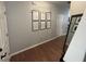 Hallway with hardwood floors and framed art pieces on the light grey walls at 532 Oakside Pl, Acworth, GA 30102