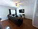 Cozy living room featuring a sleek, dark sectional, flat-screen TV, and hardwood floors at 532 Oakside Pl, Acworth, GA 30102