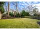 Spacious backyard featuring a well-maintained lawn, mature trees, and a wooden fence at 2603 Apple Valley Ne Rd, Brookhaven, GA 30319
