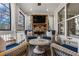 Comfortable screened porch featuring a stone fireplace, TV, and wicker seating for outdoor enjoyment at 2603 Apple Valley Ne Rd, Brookhaven, GA 30319