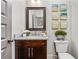 Elegant powder room featuring a marble countertop, dark wood vanity, and stylish wall decor for a sophisticated touch at 2603 Apple Valley Ne Rd, Brookhaven, GA 30319