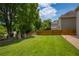 Large grassy backyard featuring a wood fence and stone retaining wall at 4652 Prater Se Way, Smyrna, GA 30080