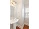 Powder room with a pedestal sink, and window provides natural light, complemented by wood floors at 4652 Prater Se Way, Smyrna, GA 30080