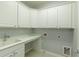 Bright laundry room with ample white cabinetry and a sink at 4652 Prater Se Way, Smyrna, GA 30080