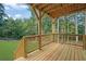 Covered wooden deck offers an outdoor space with serene views of the surrounding lush greenery at 553 Somersby Dr, Dallas, GA 30157