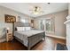 Bedroom features a gray bed frame, hardwood floors, and updated windows with decorative glass at 698 Bellemeade Nw Ave, Atlanta, GA 30318