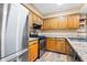 Cozy kitchen featuring wooden cabinetry, granite countertops, stainless steel appliances, and modern fixtures at 98 Hampshire Ct, Avondale Estates, GA 30002