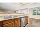 Kitchen featuring wood cabinets, granite countertops, stainless steel appliances and a view into the adjacent dining room at 98 Hampshire Ct, Avondale Estates, GA 30002