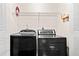 Laundry room with full-size black washer and dryer and a wire storage shelf at 98 Hampshire Ct, Avondale Estates, GA 30002