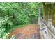 Secluded backyard with a rustic wooden fence, lush greenery, and wooden steps leading into the woods at 2122 Rockland Ct, Marietta, GA 30062