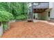 Beautiful fenced backyard with lush greenery, pine straw, and wooden deck with stairs for outdoor enjoyment at 2122 Rockland Ct, Marietta, GA 30062