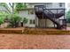 Expansive backyard featuring a wooden deck with stairs, retaining wall, and mature trees for privacy at 2122 Rockland Ct, Marietta, GA 30062