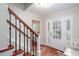 Bright foyer with hardwood floors, staircase with dark wood railing, and a bench at 2122 Rockland Ct, Marietta, GA 30062