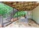 Covered patio with stone flooring, wooden stairs, and lush greenery offering a shaded outdoor retreat at 2122 Rockland Ct, Marietta, GA 30062