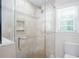 Bright bathroom shower with glass doors, mosaic tile accent, and stone-look tile surround at 2122 Rockland Ct, Marietta, GA 30062