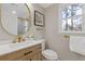 Bright bathroom featuring wood vanity with gold fixtures and a round mirror at 2453 Paul Nw Ave, Atlanta, GA 30318