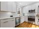 Well-lit kitchen with stainless steel appliances, white cabinets, quartz countertops, and hardwood floors at 2453 Paul Nw Ave, Atlanta, GA 30318
