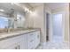Bathroom features a double vanity with granite countertop, framed mirrors, and tiled floor at 4085 Fawn Valley Dr, Loganville, GA 30052