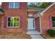 Close-up of the front entrance showcasing the brick facade, white door, and manicured landscaping at 4085 Fawn Valley Dr, Loganville, GA 30052