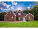 Charming red brick home with a lush green lawn and mature trees at 4085 Fawn Valley Dr, Loganville, GA 30052