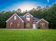Charming red brick home with a lush green lawn and mature trees at 4085 Fawn Valley Dr, Loganville, GA 30052