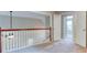Open hallway with wood railing, neutral carpeting, and view into an adjacent room at 4085 Fawn Valley Dr, Loganville, GA 30052