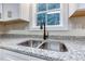 Kitchen close up of stainless steel sink, goose neck faucet and granite countertops at 4085 Fawn Valley Dr, Loganville, GA 30052