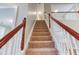 Carpeted staircase with stained wood handrail and white spindles at 4085 Fawn Valley Dr, Loganville, GA 30052