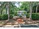 Exterior of a townhome surrounded by lush trees and a small brick patio area at 1750 Clairmont Rd # 35, Decatur, GA 30033