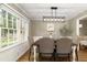 Elegant dining room with a modern chandelier and large windows overlooking a landscaped yard at 3719 Northbrook Ct, Atlanta, GA 30340