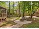 Cozy backyard fire pit with seating, surrounded by a stone border and mature trees at 3719 Northbrook Ct, Atlanta, GA 30340